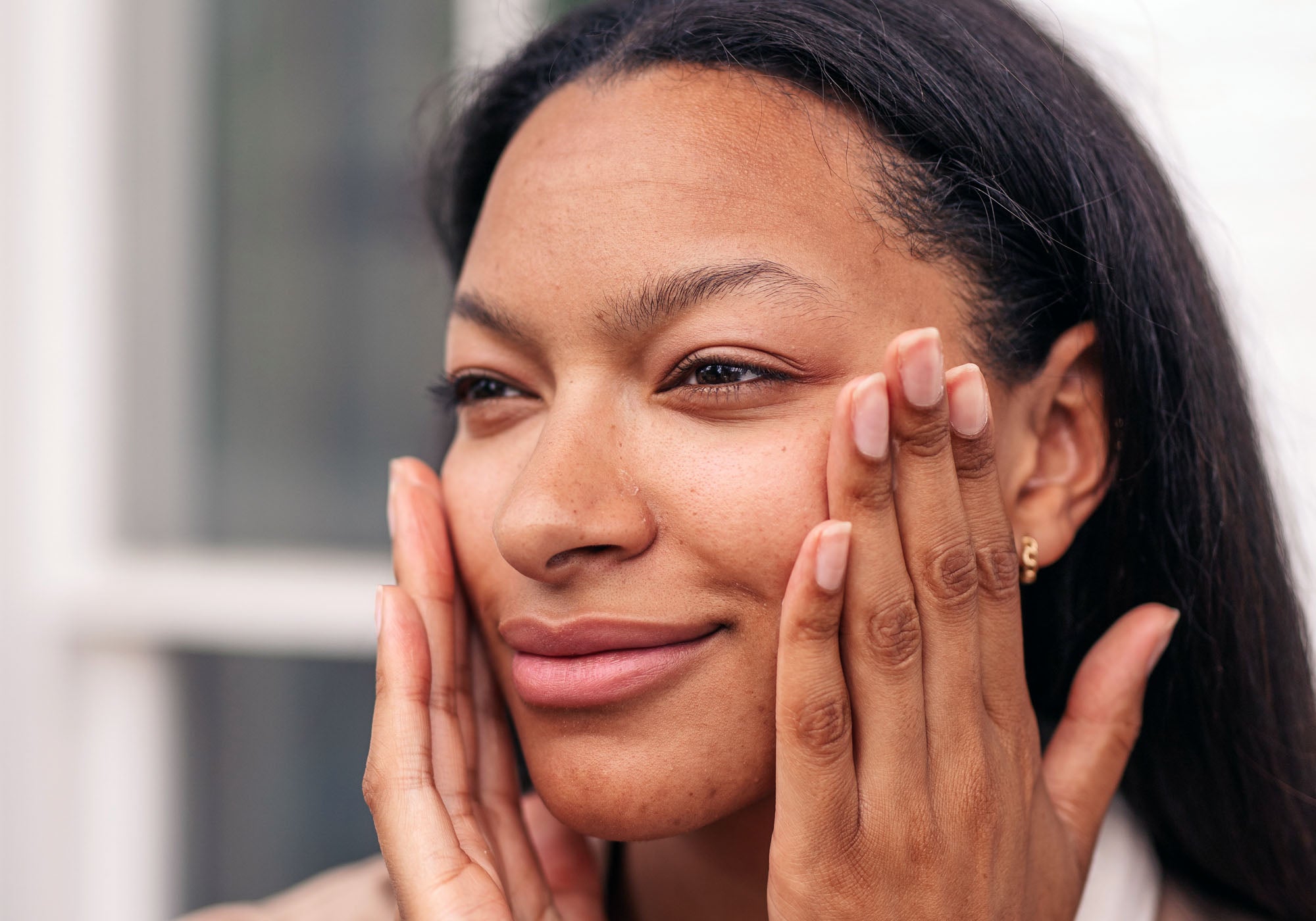 African-American woman putting hydrogel on face