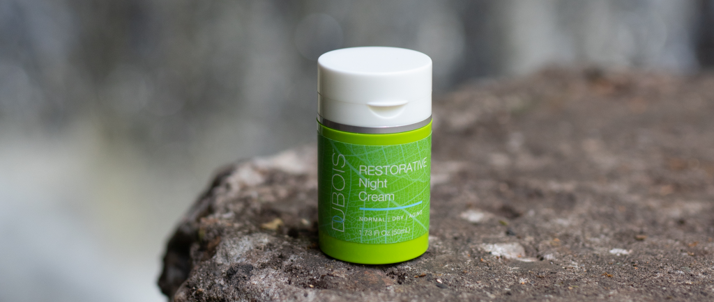 restorative night cream on a rock outside