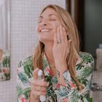 woman smiling and applying serum