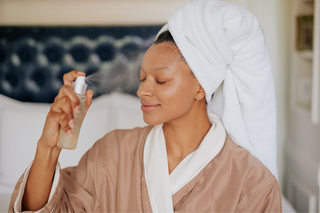 woman spraying facial mist on face